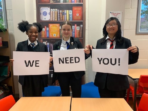 Students holding We Need You sign