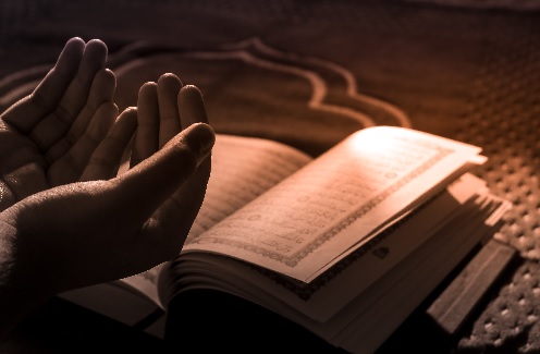 Image of a book & praying hands
