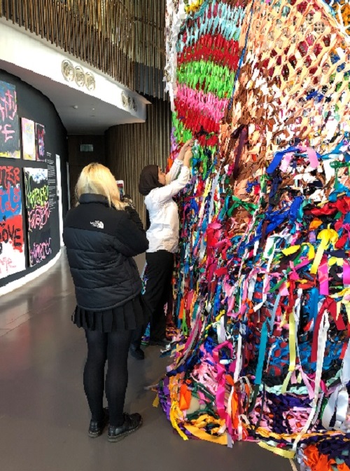 Students standing admiring a 'Textile Wall'