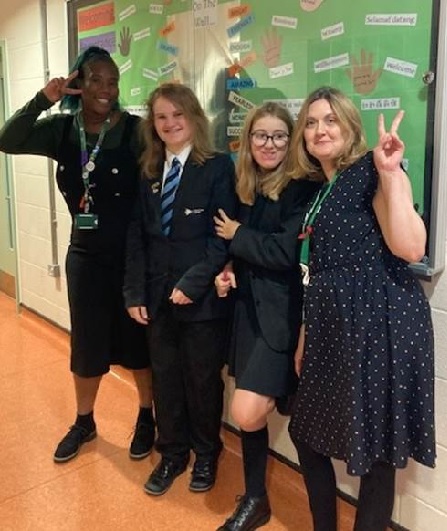 A photo of Ms Andrew-Cummings with students and Ms Alexander